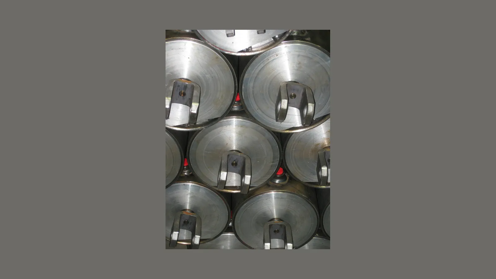 Stack of machined hydraulic swivel bodies with clevis ends, viewed end-on