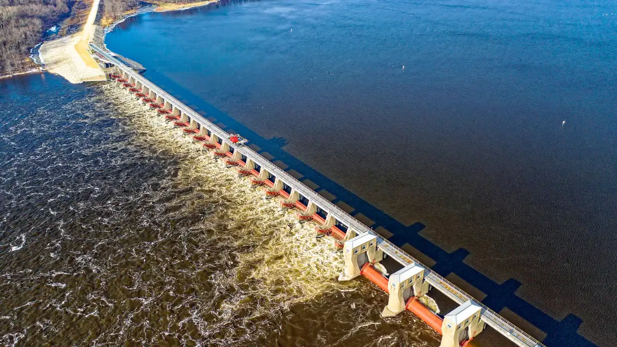 Aerial view of a dam spillway with penstock pipes carrying bulk water flow