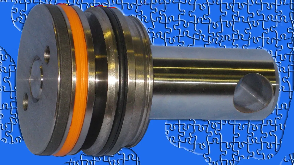 Polished aluminium piston crown with bright orange seal ring, the rotating-equipment part rotary unions feed